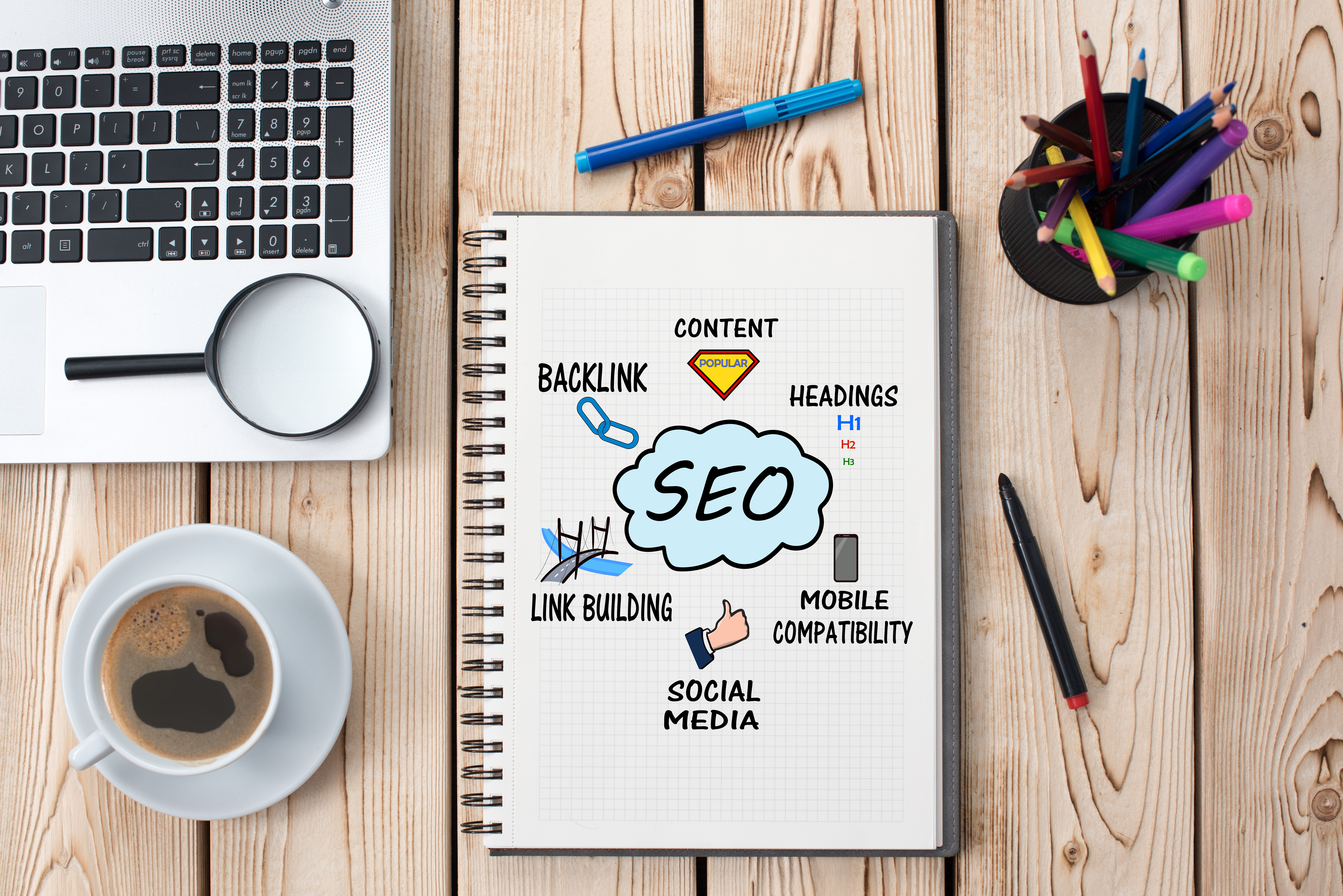 SEO (search engine optomization) with SEO ideas around written around it, sorrounded by office materials